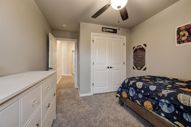 carpeted bedroom with ceiling fan and a closet