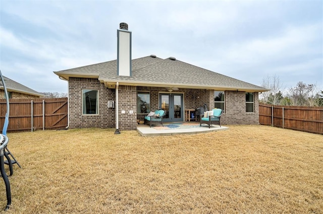 back of property featuring french doors, a patio, and a lawn