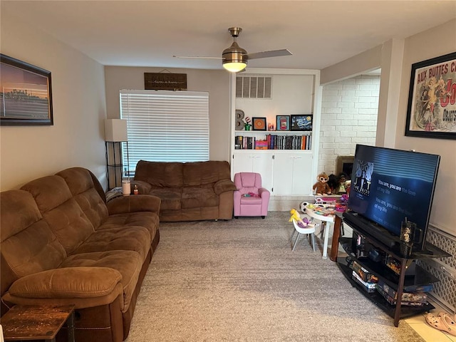 carpeted living room featuring ceiling fan and built in shelves