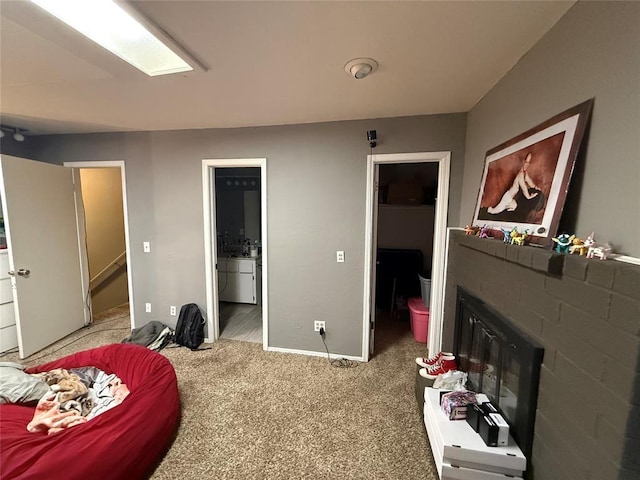 bedroom with a walk in closet, connected bathroom, and carpet