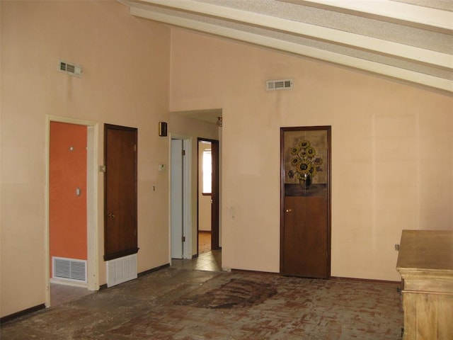 hall with beam ceiling and high vaulted ceiling