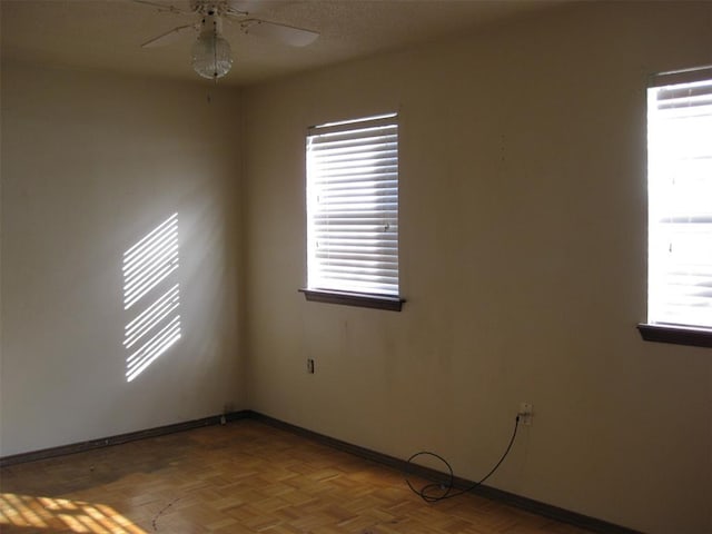 empty room with ceiling fan and parquet flooring