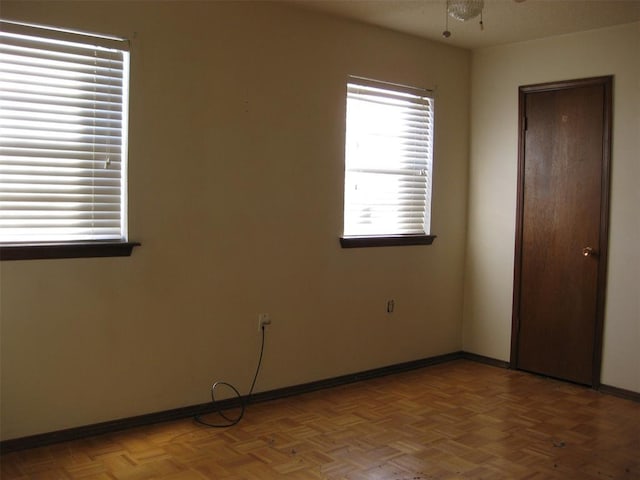 unfurnished room featuring ceiling fan and parquet flooring