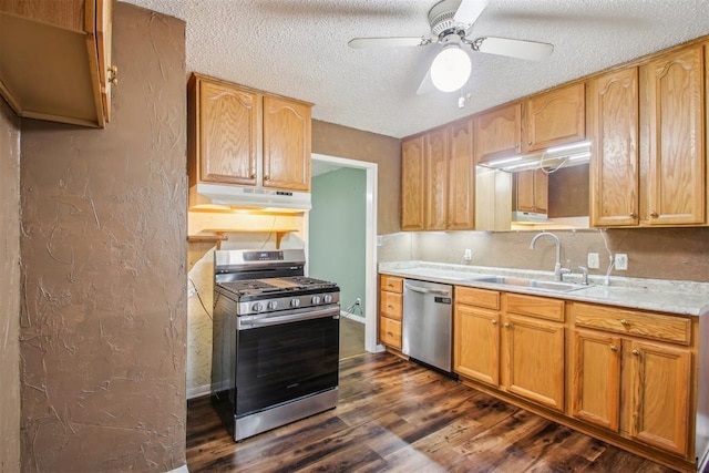 kitchen with dark hardwood / wood-style flooring, a textured ceiling, stainless steel appliances, ceiling fan, and sink