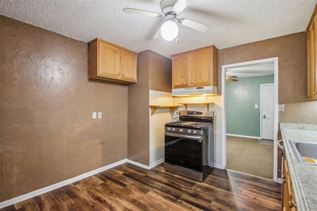 kitchen featuring a textured ceiling, stainless steel gas stove, ceiling fan, and dark wood-type flooring