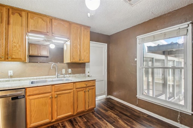 kitchen featuring dark hardwood / wood-style flooring, sink, stainless steel dishwasher, and a textured ceiling