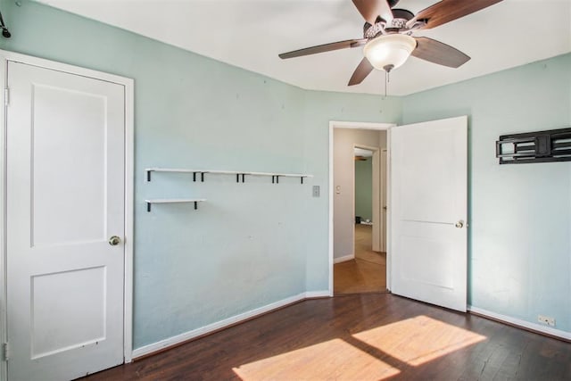 unfurnished bedroom featuring dark hardwood / wood-style flooring and ceiling fan