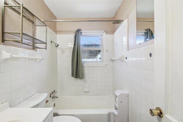 full bathroom with vanity, toilet, tile walls, and tiled shower / bath combo