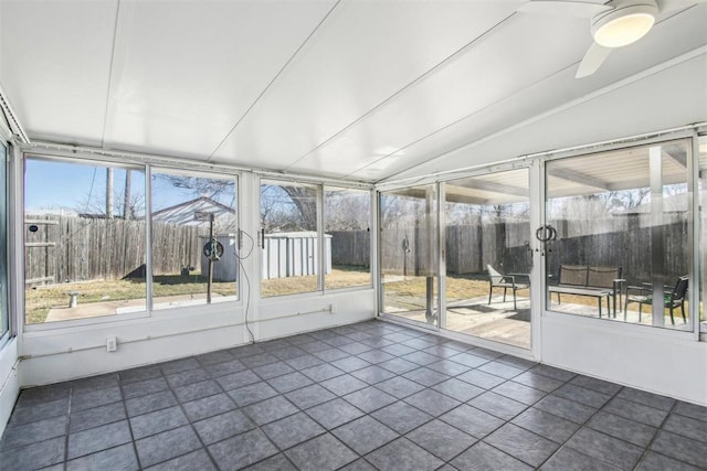 unfurnished sunroom with ceiling fan and vaulted ceiling