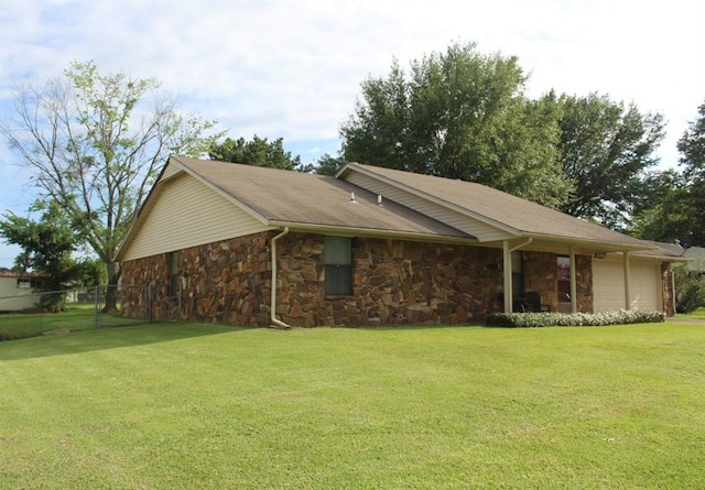 rear view of house featuring a garage and a yard