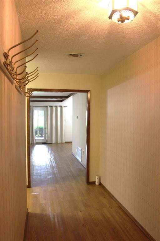 corridor with a textured ceiling and dark hardwood / wood-style floors