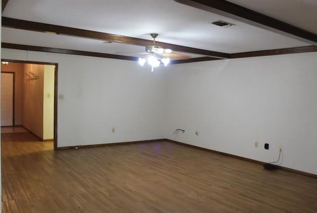 spare room featuring beamed ceiling, dark hardwood / wood-style flooring, and ceiling fan