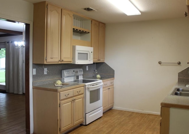 kitchen with light wood-type flooring, light brown cabinets, white appliances, and tasteful backsplash