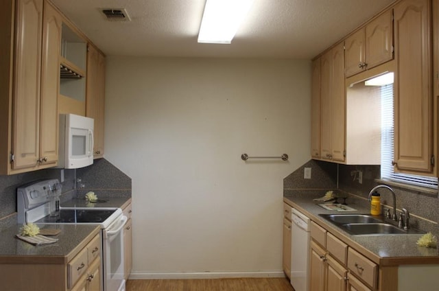 kitchen featuring sink, backsplash, light hardwood / wood-style floors, white appliances, and light brown cabinetry