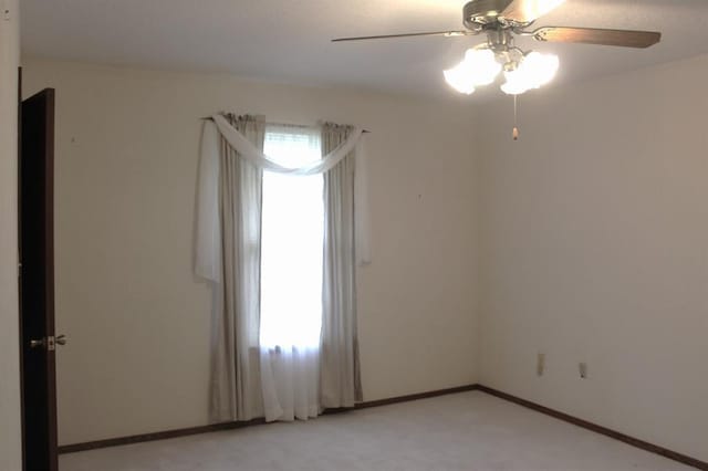 unfurnished room featuring ceiling fan and light colored carpet