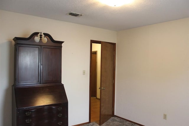 unfurnished bedroom featuring carpet floors and a textured ceiling