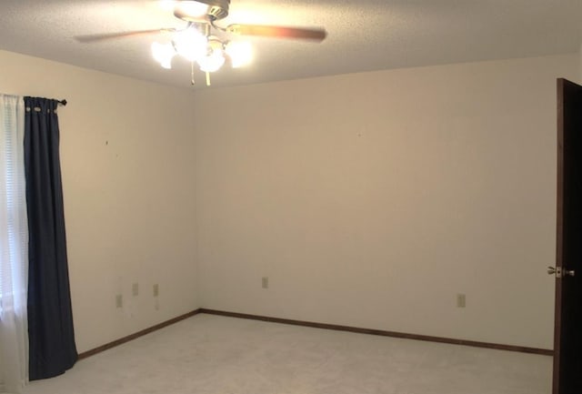 empty room featuring ceiling fan and light colored carpet