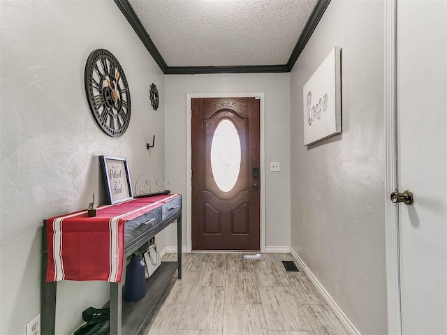 foyer entrance featuring light hardwood / wood-style flooring, a textured ceiling, and ornamental molding