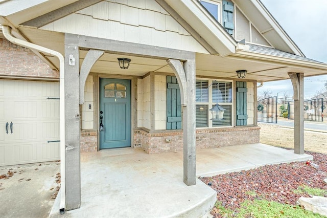 doorway to property with covered porch and a garage