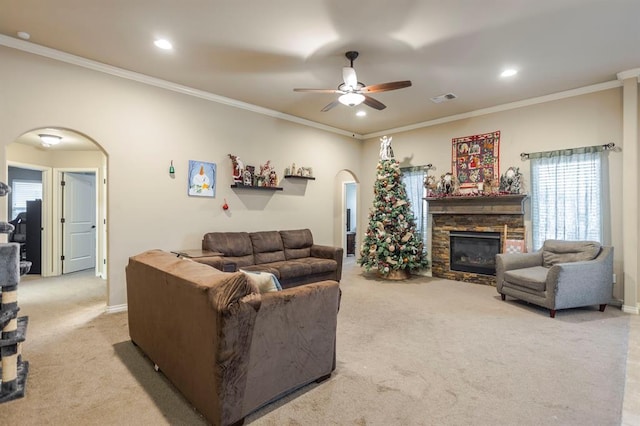 living room featuring a fireplace, light carpet, ceiling fan, and ornamental molding