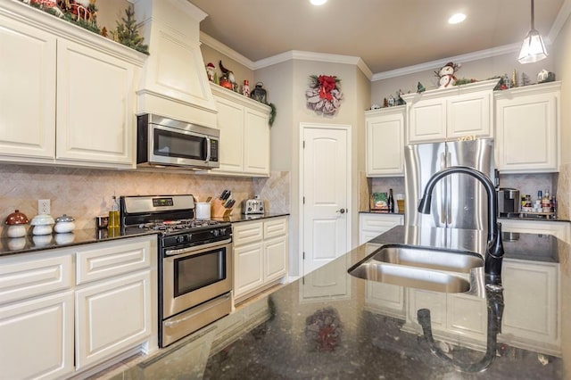 kitchen with appliances with stainless steel finishes, tasteful backsplash, ornamental molding, sink, and dark stone countertops