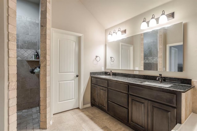 bathroom with tile patterned floors, a shower, vanity, and vaulted ceiling