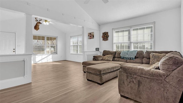 living room with light wood-type flooring, vaulted ceiling, and ceiling fan