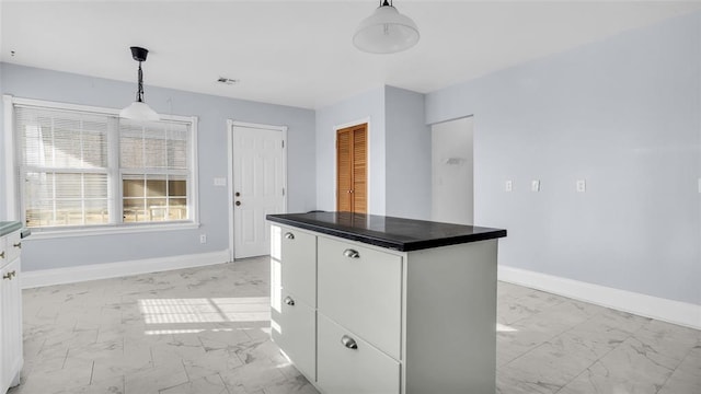 kitchen with a center island, white cabinetry, and hanging light fixtures