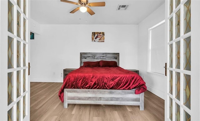 bedroom with ceiling fan, french doors, and light wood-type flooring