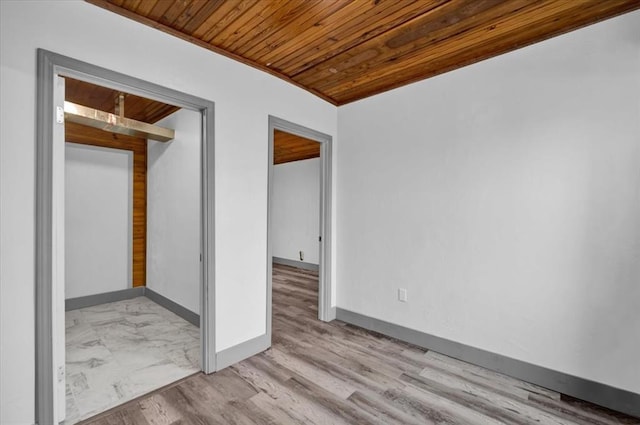 empty room with light hardwood / wood-style floors and wooden ceiling