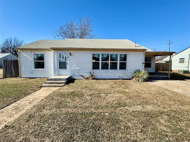 ranch-style house with cooling unit, a carport, and a front yard