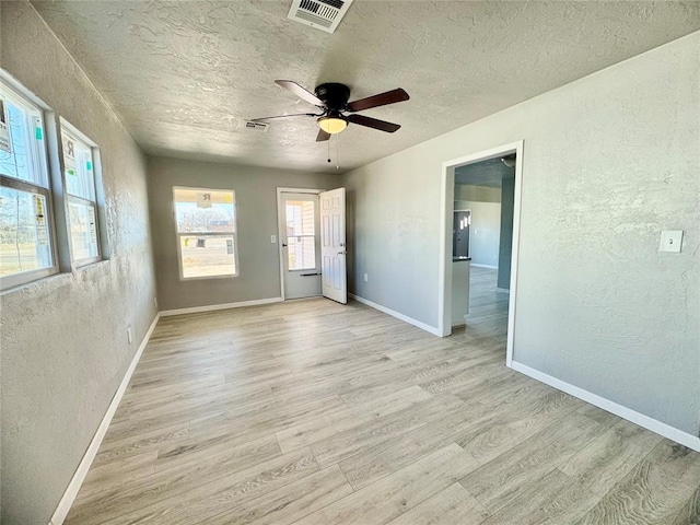 unfurnished room featuring ceiling fan, a textured ceiling, and light wood-type flooring