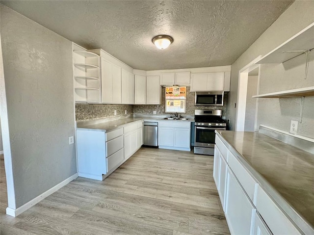 kitchen featuring stainless steel counters, sink, white cabinetry, and appliances with stainless steel finishes