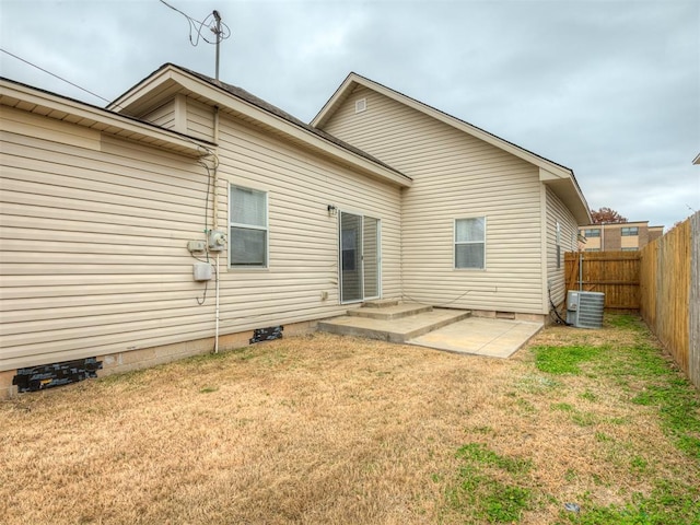 back of house with a lawn, central AC, and a patio area