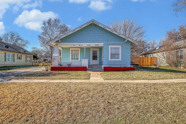 bungalow-style house featuring covered porch and a front yard