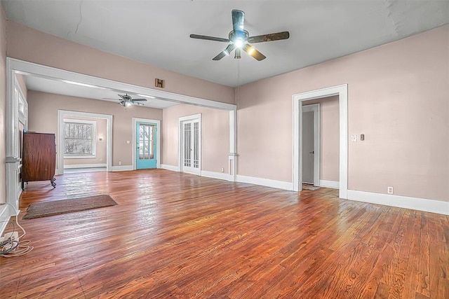 unfurnished living room with ceiling fan and wood-type flooring