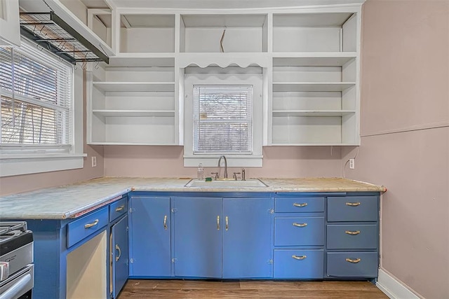 kitchen with sink, hardwood / wood-style floors, stove, and blue cabinets