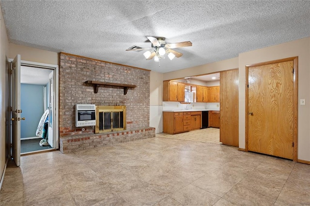 unfurnished living room with heating unit, ceiling fan, a textured ceiling, and a brick fireplace