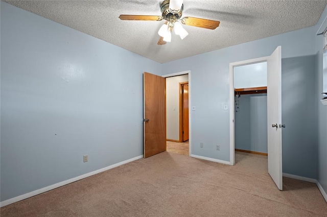 unfurnished bedroom with light carpet, a textured ceiling, a closet, and ceiling fan