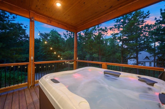 deck at dusk with a hot tub