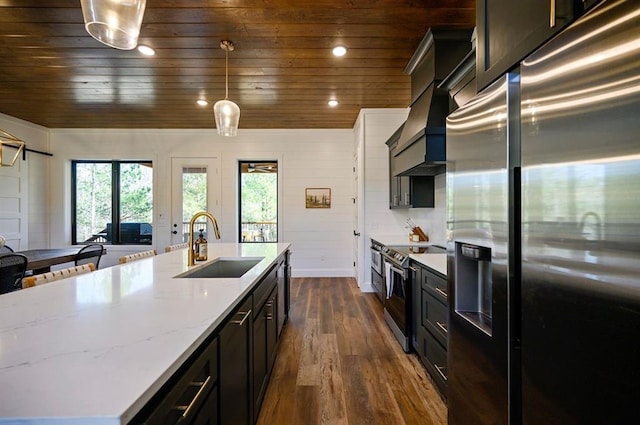 kitchen featuring pendant lighting, custom exhaust hood, sink, appliances with stainless steel finishes, and wood ceiling