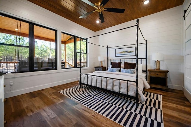 bedroom with ceiling fan, dark wood-type flooring, and wood ceiling