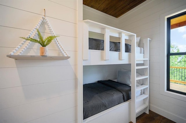 bedroom featuring wooden walls