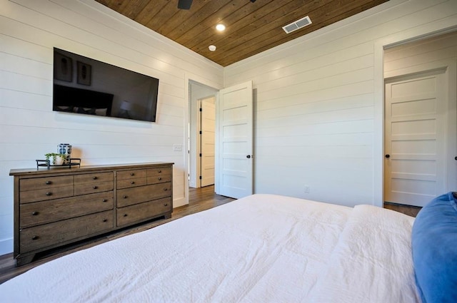 bedroom with dark hardwood / wood-style flooring, wood walls, and wood ceiling