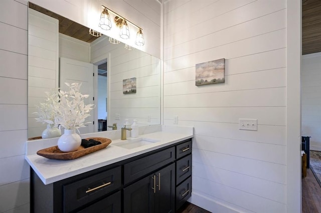 bathroom featuring vanity and wooden walls