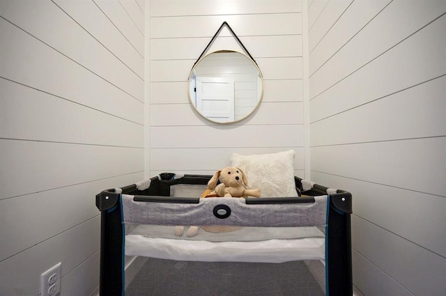 bedroom featuring wood walls