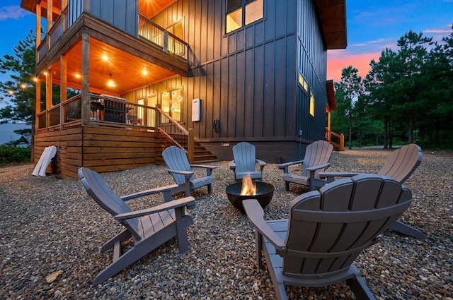 patio terrace at dusk with a balcony and an outdoor fire pit