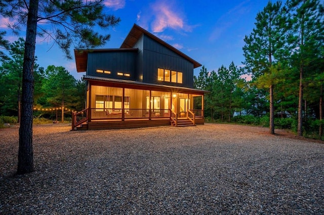 back house at dusk with covered porch