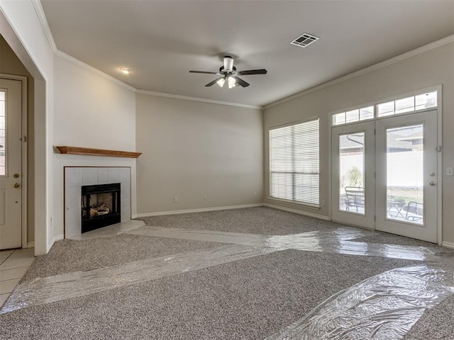 unfurnished living room with a tile fireplace, light colored carpet, ceiling fan, and ornamental molding