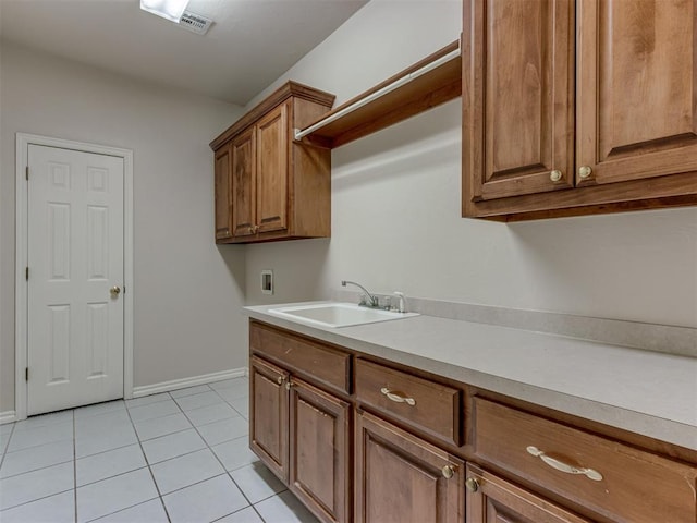 clothes washing area featuring light tile patterned flooring, cabinets, sink, and hookup for a washing machine